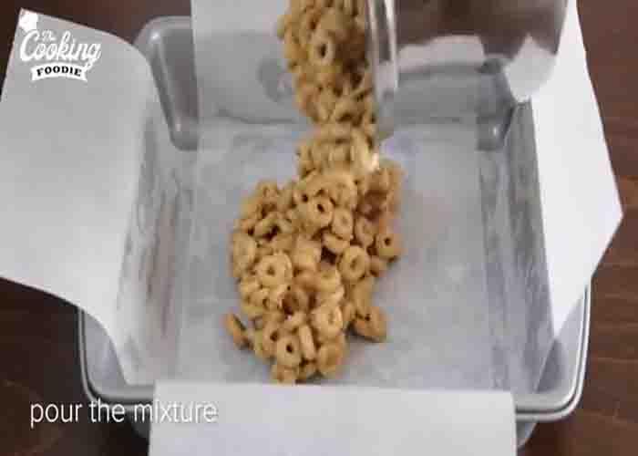 Transferring the cereal bars mixture into a baking tray