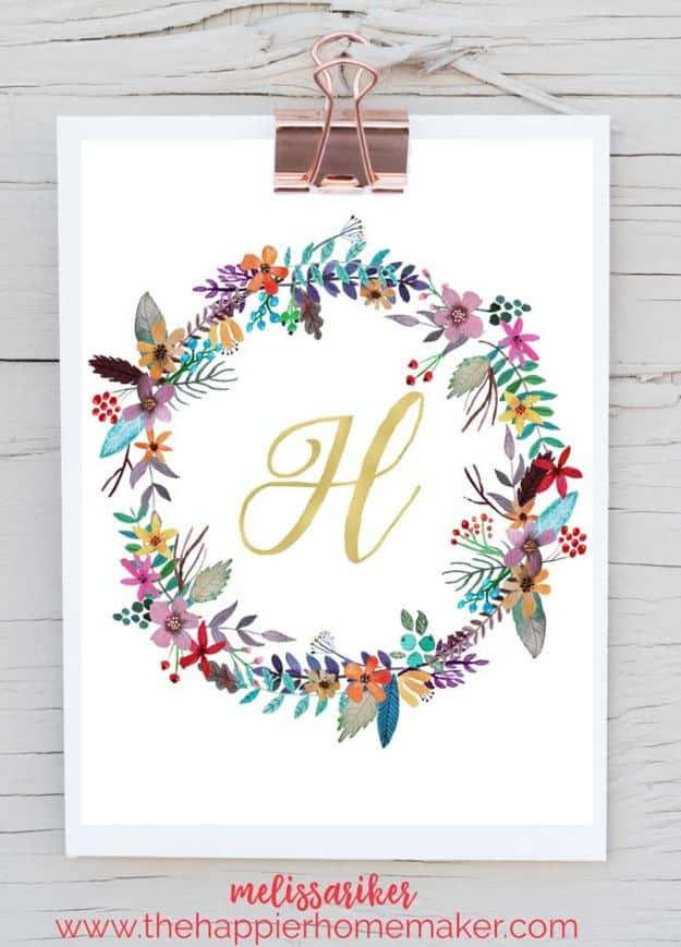 Gold monogram letter H inside a watercolor floral wreath printable, clipped to a white wood wall for display