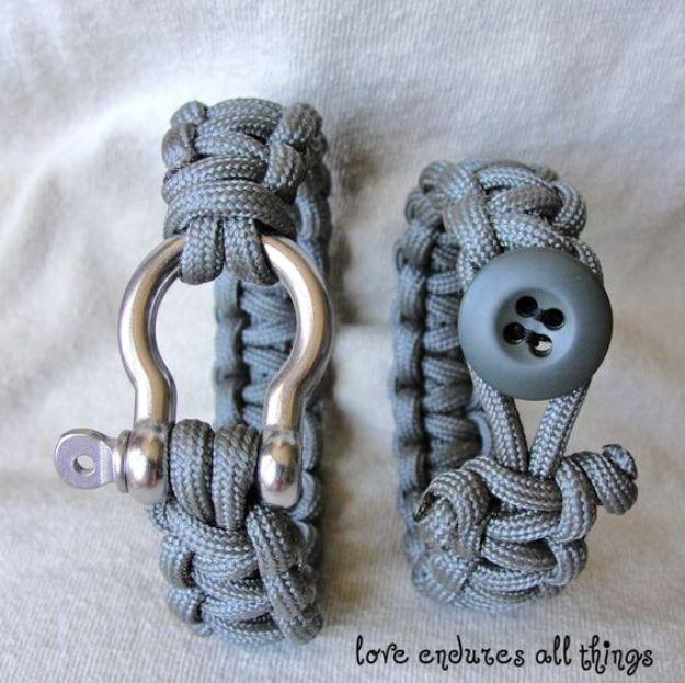 Two gray paracord bracelets on white cloth, one closed with a metal shackle and the other with a button
