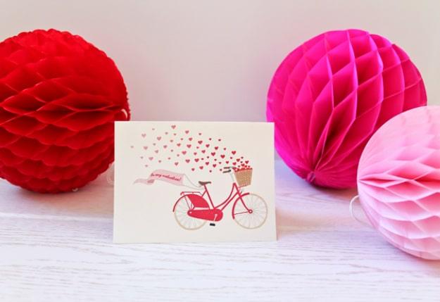 Last minute printable Valentine's card with an illustrated bicycle carrying a red heart, folded and ready