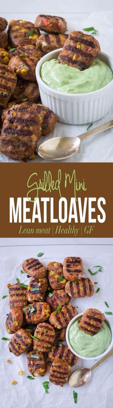 Grilled mini turkey meatloaves on a white platter with a small bowl of green avocado and yogurt sauce