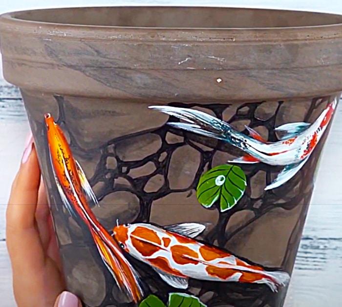 Paint Coy Fish Onto A Clay Pot With Acrylics