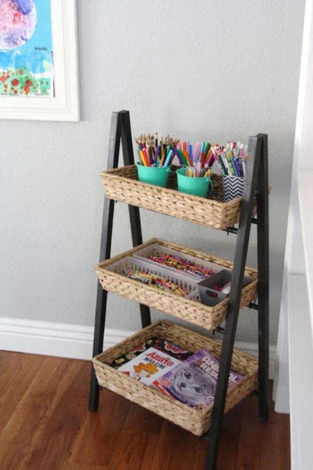 Simple organized childrens art supplies, a black ladder shelf with woven baskets of pencils crayons and coloring books