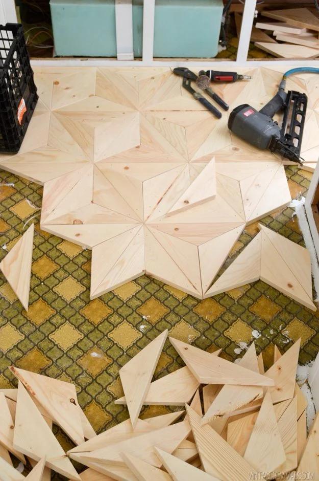 Geometric wood flooring, pine triangles nailed into star shapes over green tile with a brad nailer and tools