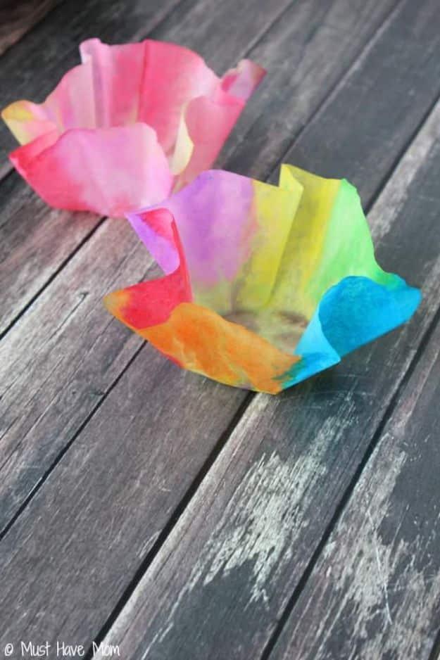 Small bowl made from a watercolor painted coffee filter stiffened with starch, sitting on gray wood decking