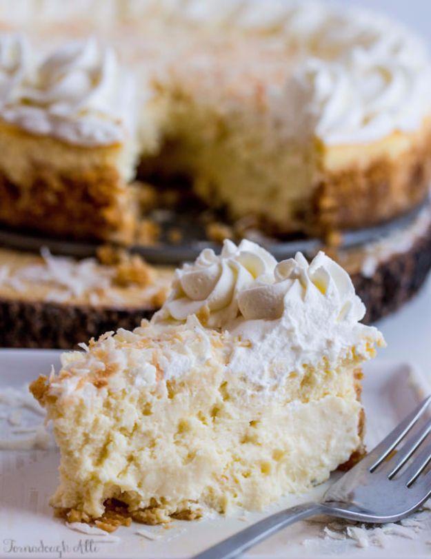 Coconut cream cheesecake with piped whipped cream and toasted coconut on top, one slice on a plate with a fork