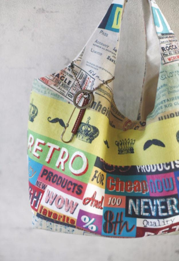 Slouchy hobo bag in printed cotton covered in retro advertising type and crowns with a single shoulder strap