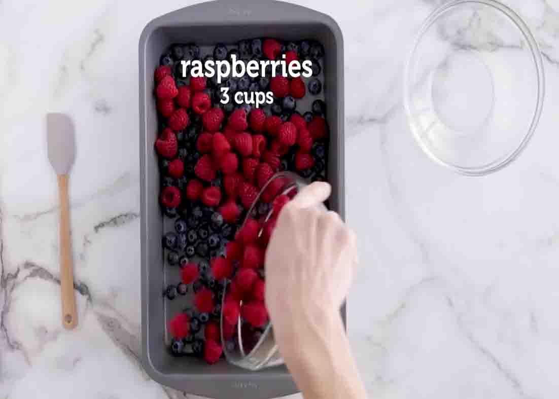 Adding the berries on the baking pan for the mixed berry dump cake