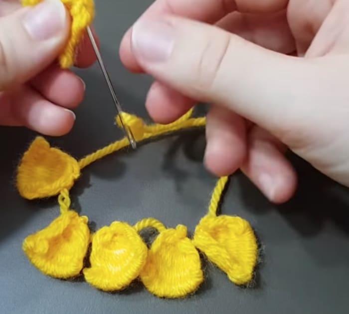Make a yarn flower out of yarn and a fork