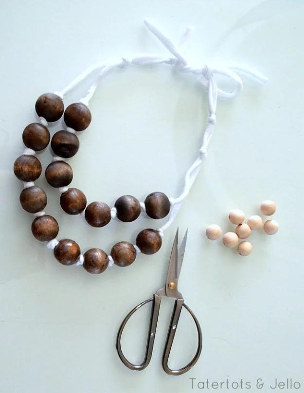Easy DIY wood and ribbon necklaces, a double strand of dark wooden beads on white ribbon beside small scissors