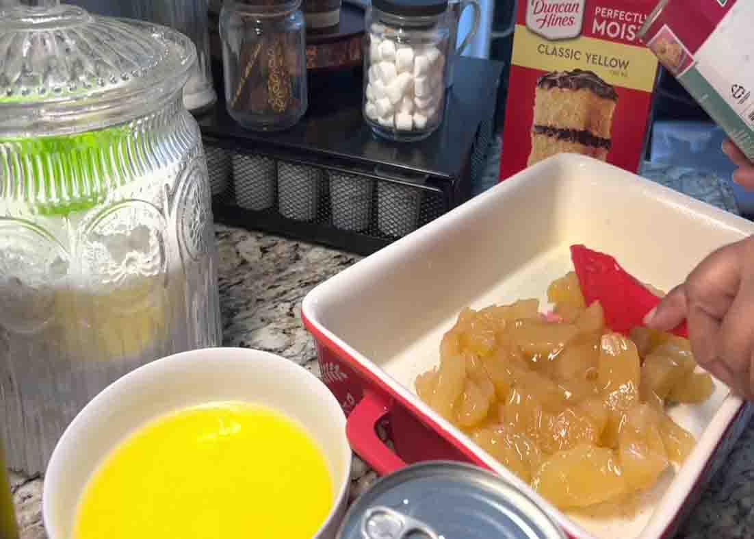 Adding the apple filling at the bottom of the baking dish