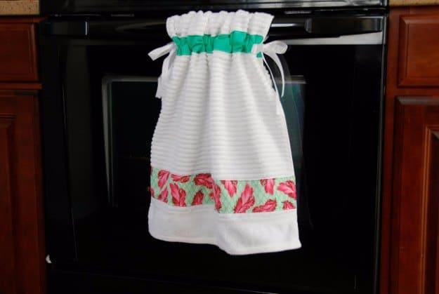 Stay put kitchen towel, a home sewing project with a white waffle towel gathered on green ribbon ties on an oven door