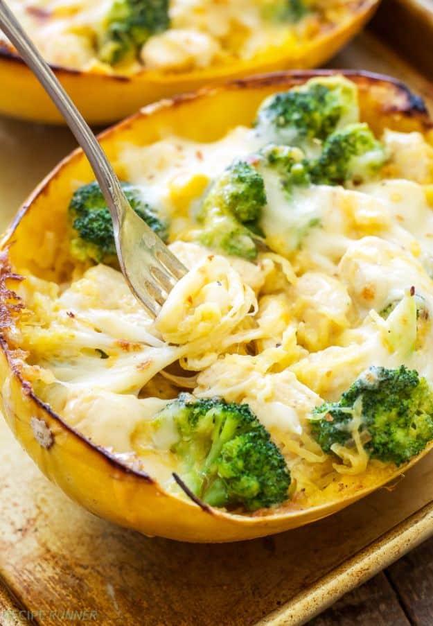 Cheesy chicken and broccoli stuffed spaghetti squash halves filled with strands, florets and melted cheese