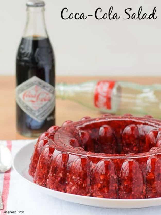Coca Cola salad, a deep red cherry gelatin ring mold on a white plate with vintage Coke bottles behind it