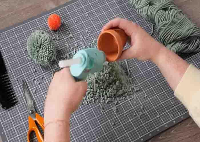 Attaching the pom pom cactus to the terracotta pot