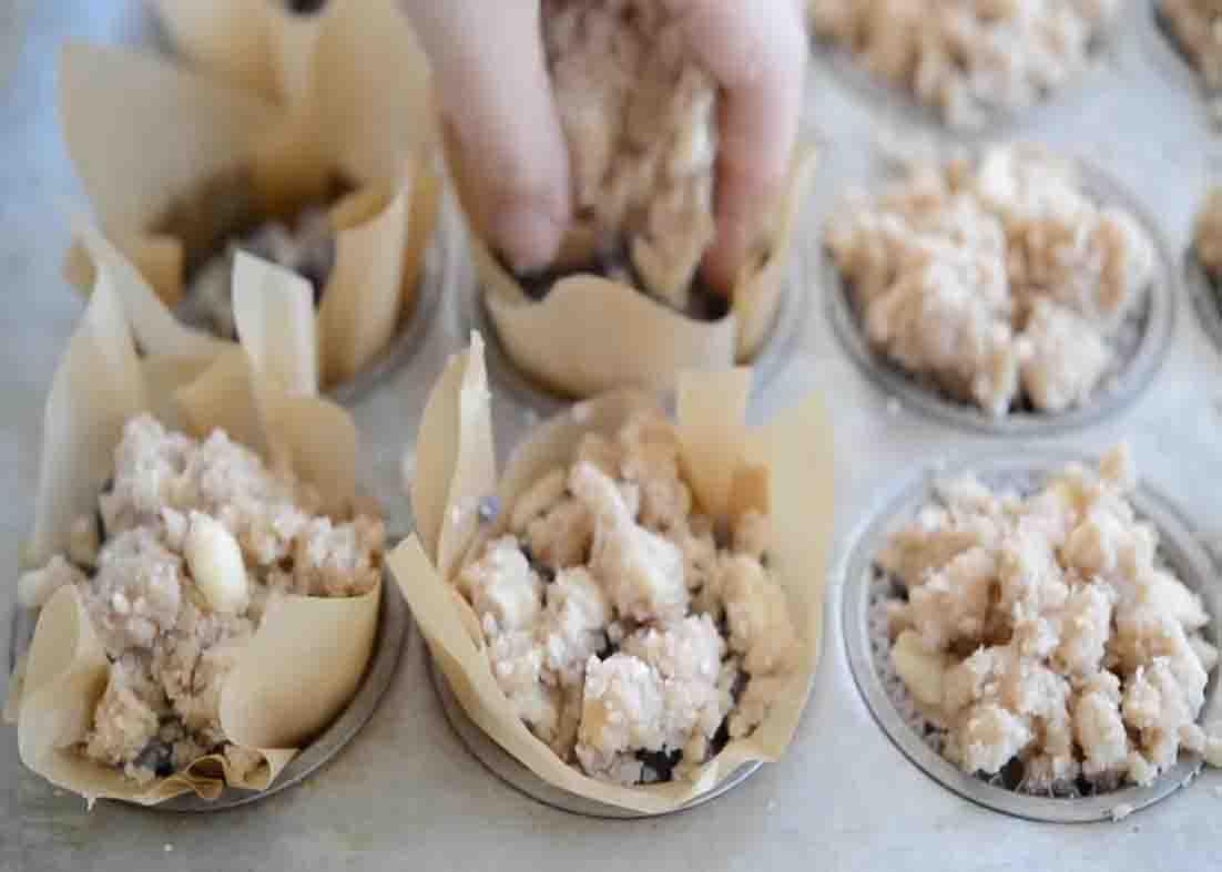 Putting the blueberry muffin batter to each muffin cups