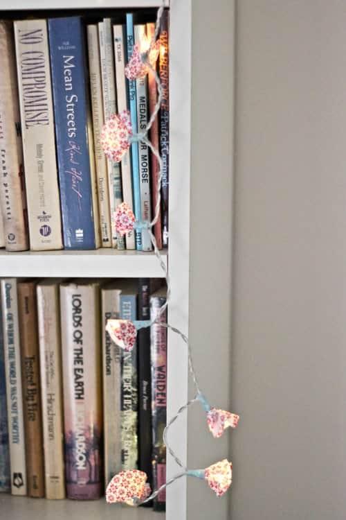 Battery fairy lights with small circles of patterned wrapping paper folded up around each bulb like shades