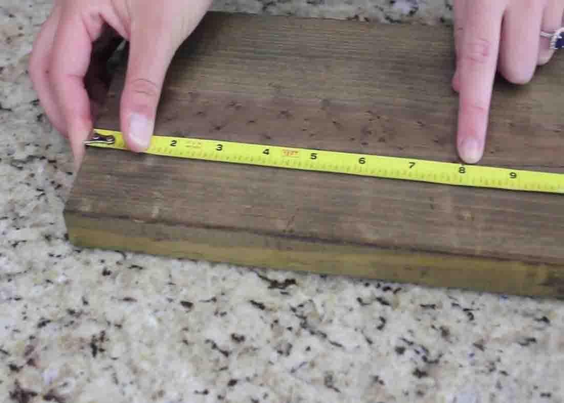 Measuring the wood to attach the mason jars