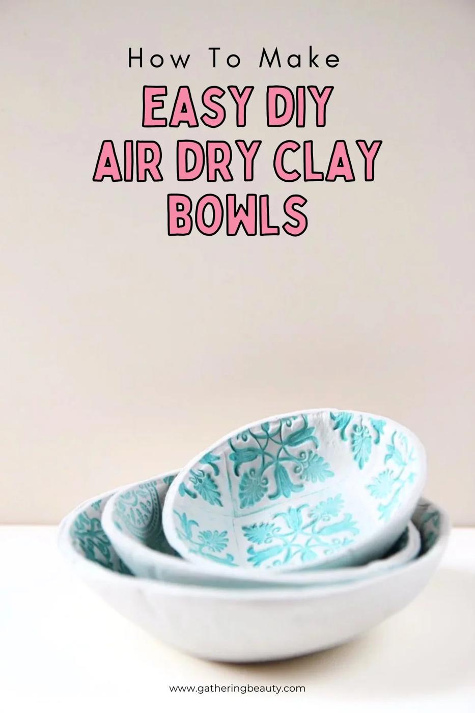 Small white air dry clay bowls stamped with lace and floral patterns, curved like ring dishes on a wood table