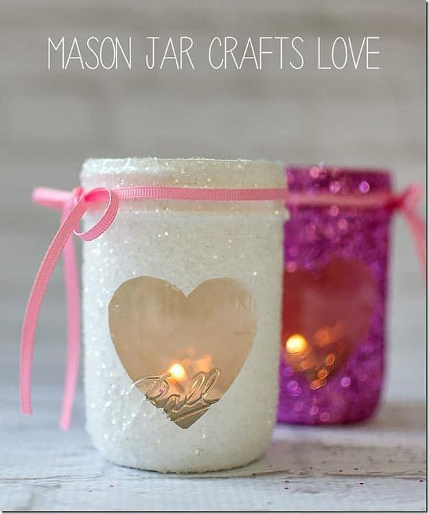 Mason jar votives coated inside with pink and red glitter glowing from flameless tea lights as a homemade gift