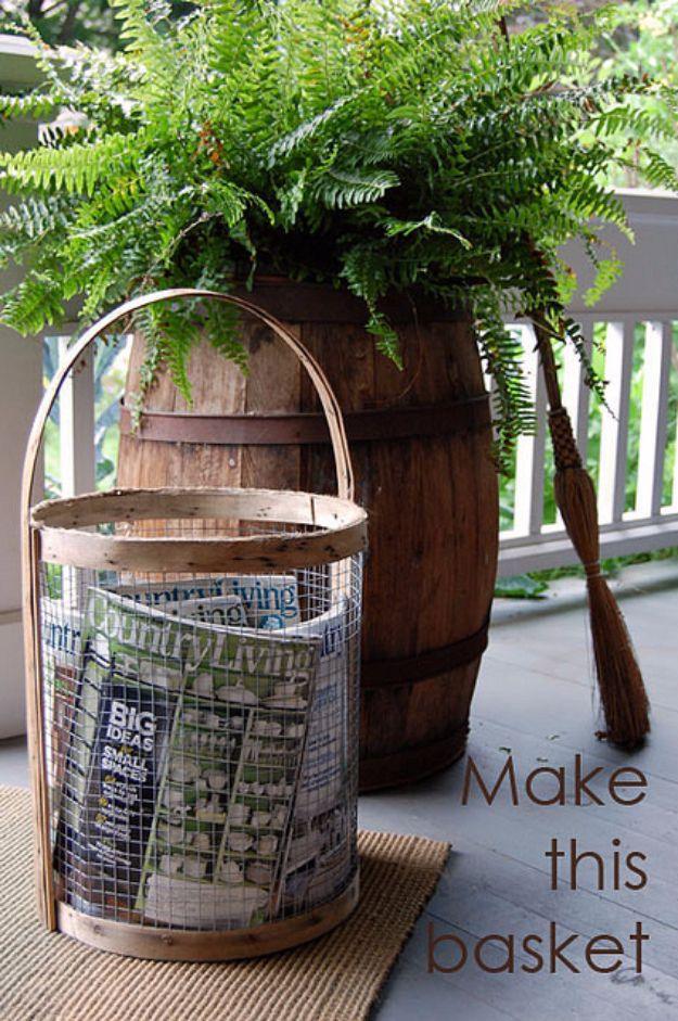 A large wire mesh basket with leather handles holds split kindling on a hearth beside a whitewashed brick fireplace