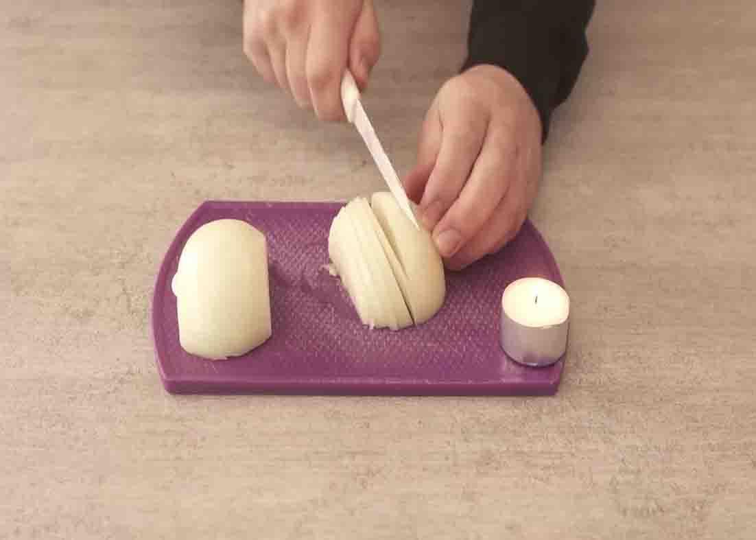 Cutting onions while a candle is lit