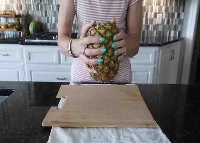 Tapping the pineapple to loosen the insides