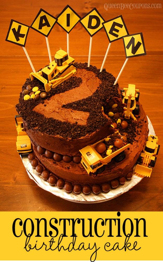 Two tier chocolate construction birthday cake with toy diggers and yellow paper name signs on sticks