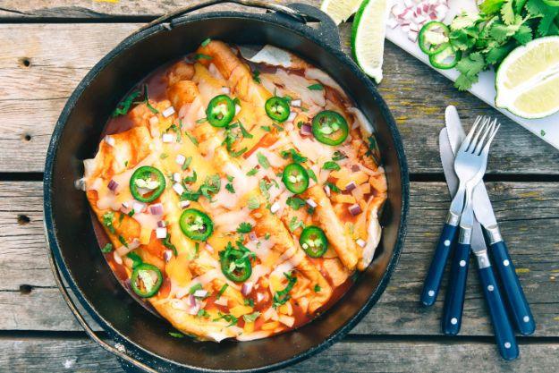 Enchiladas rolled and baked together in a dutch oven with red peppers, black beans and melted cheese