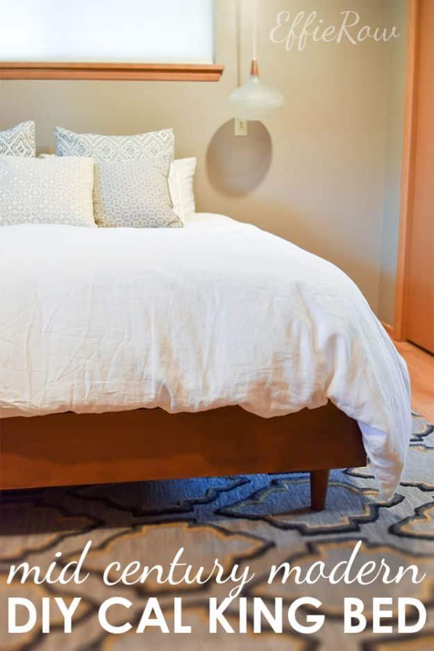 Mid century modern platform bed in warm stained wood with tapered legs and white bedding, pendant light and patterned rug