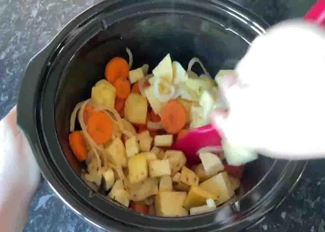 Adding the sausage casserole ingredients to the slow cooker