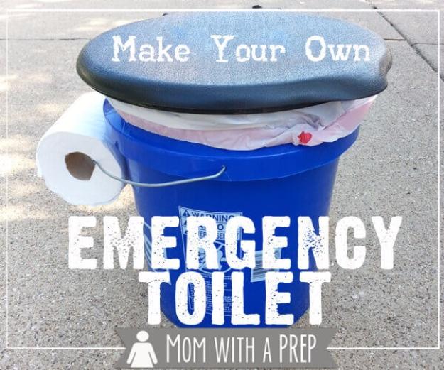 Blue five gallon bucket emergency toilet with a padded seat lid and a toilet paper roll on the pavement