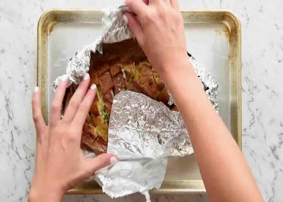 Wrapping the cheese and garlic crack bread in a foil before baking