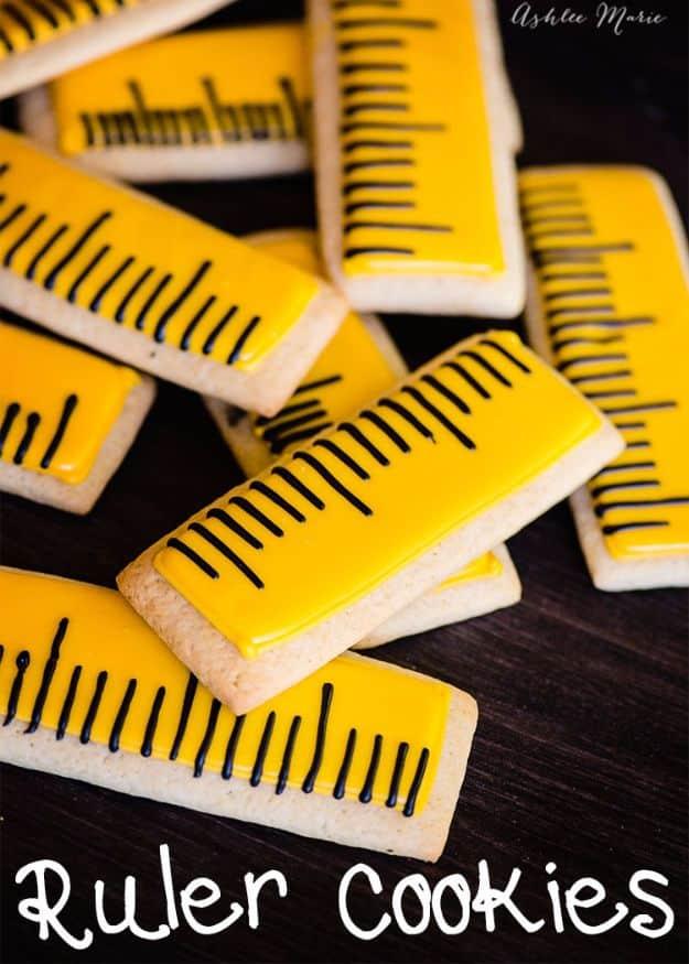Ruler sugar cookies iced yellow with piped black measurement markings and numbers, back to school treats