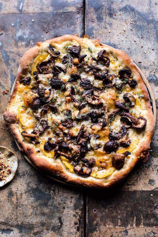 Dark rustic mushroom pizza topped with browned mushrooms, goat cheese and thin squash rounds on a metal pan