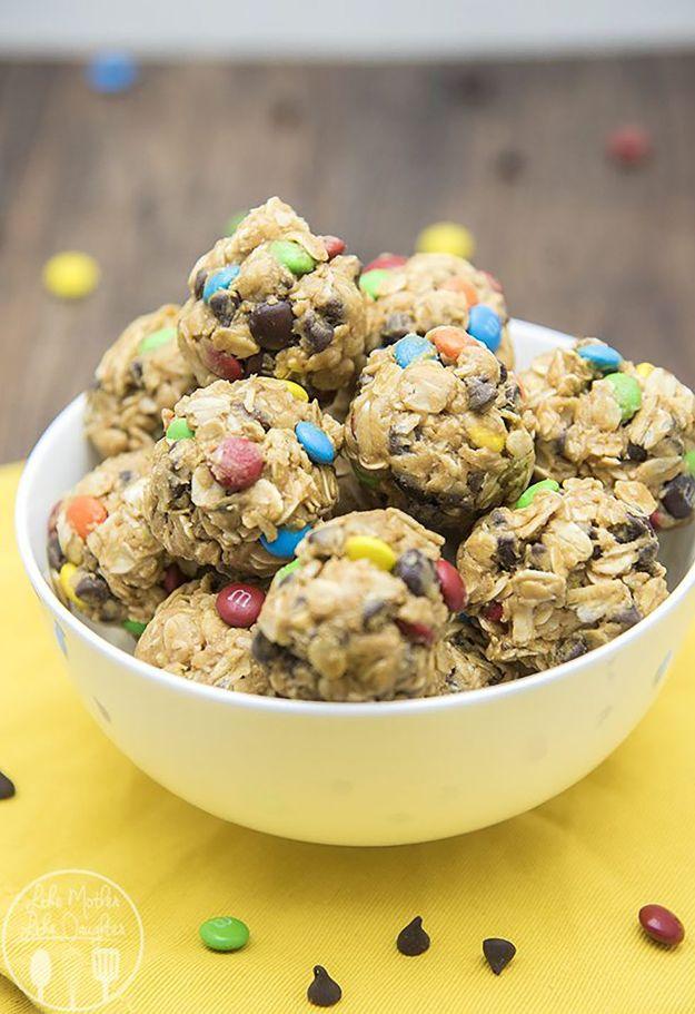 No bake monster cookie granola bar bites, oat balls studded with mini M and Ms in a white bowl on yellow