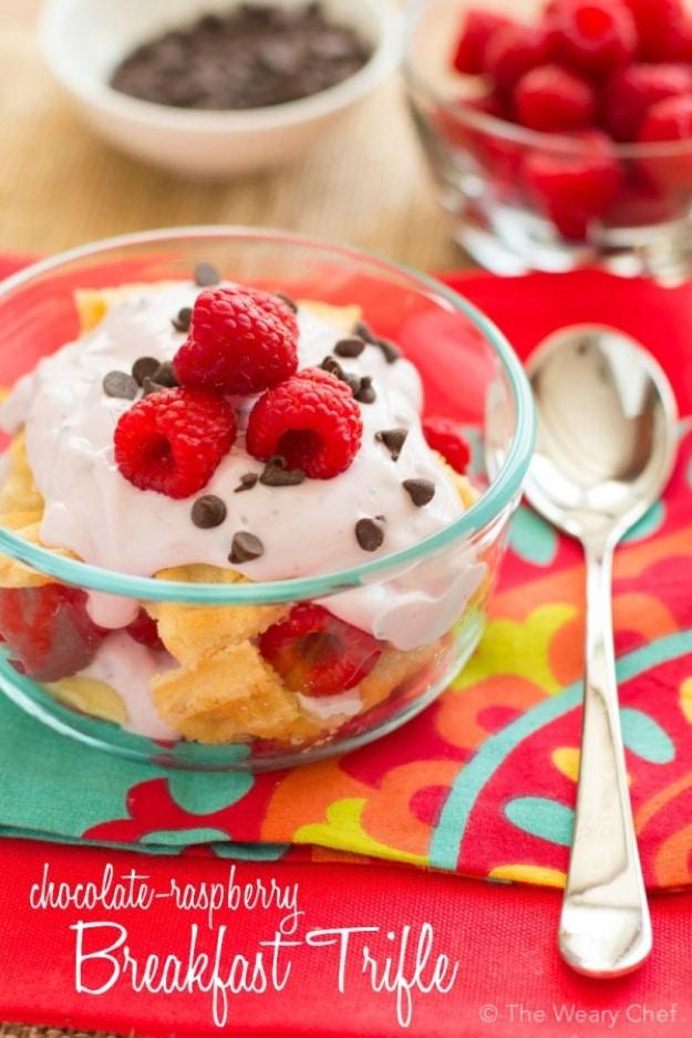 Typeset pin graphic of a glass bowl of breakfast trifle with sponge, white topping, raspberries and chocolate chips