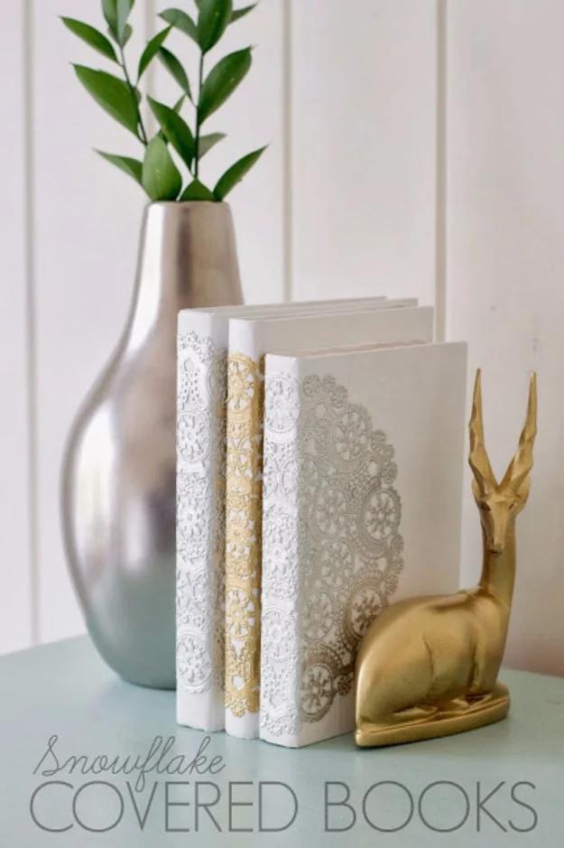 DIY snowflake covered books graphic, white painted books decoupaged with cream and gold doilies by a gold deer