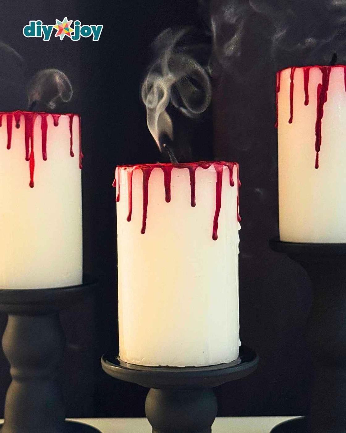 DIY bloody candle for Halloween with red crayon blood drips running down a white pillar candle, the easiest Halloween decor.