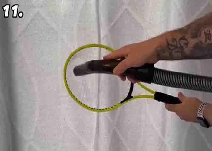 Cleaning the curtain with a vacuum and a tennis racket