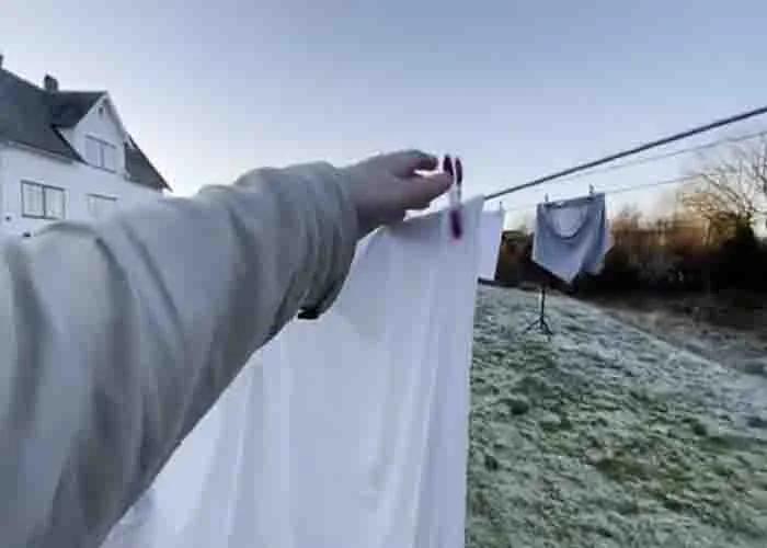 Using pegs to hang up the clothes outside to dry them
