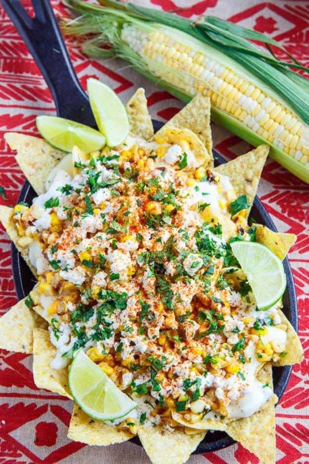 Mexican street corn nachos loaded with charred corn, feta, cilantro and Monterey Jack cheese sauce for a backyard BBQ
