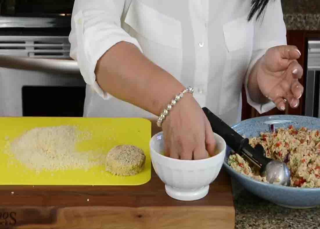 Dredging the tuna cakes with breadcrumbs