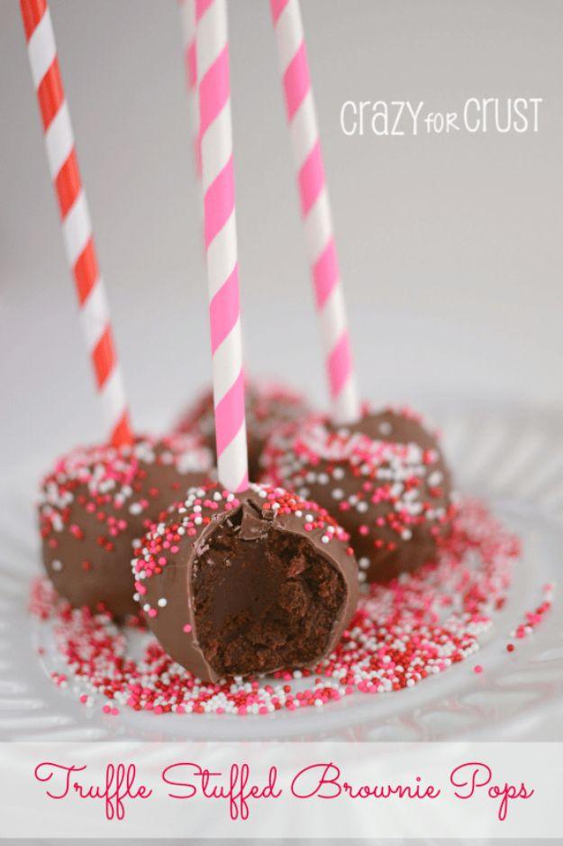 Truffle stuffed brownie pops with a chocolate ganache center sealed inside brownie and dipped hard, set on a rack