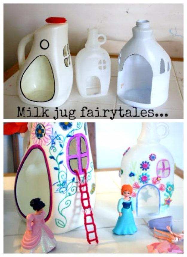Three milk jug fairy houses drawn and cut with doors and windows, decorated in marker, with small toy figurines beside them