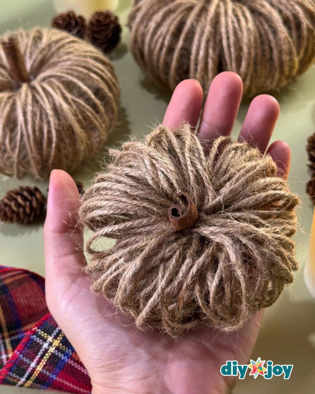 Pumpkin crafts - handmade twine pumpkin styled on a rustic wood table as DIY fall decor made from a toilet paper roll.