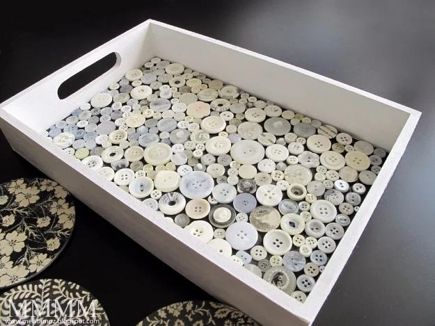 Button tray, a white wooden tray with its base filled edge to edge in cream and pearl buttons over black card