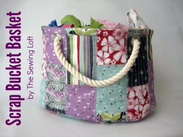 Patchwork fabric bucket basket in purple, teal and red prints with a thick white rope handle, filled with fabric scraps