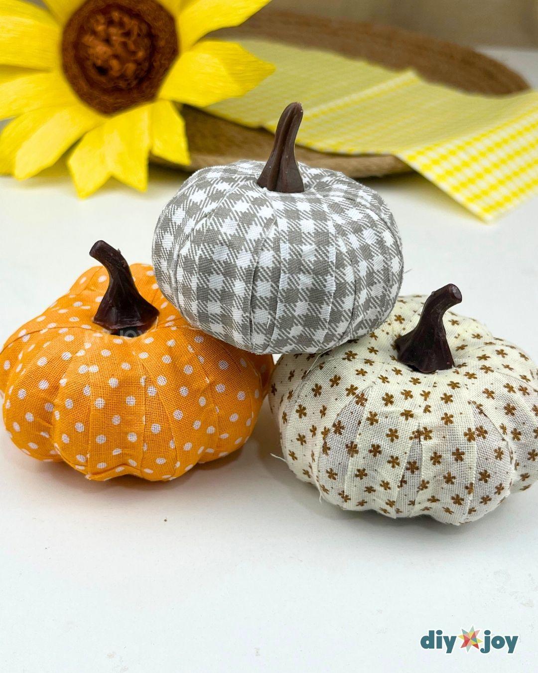Pumpkin Crafts - three faux pumpkins wrapped in gray gingham, orange polka dot and cream floral fabric on display