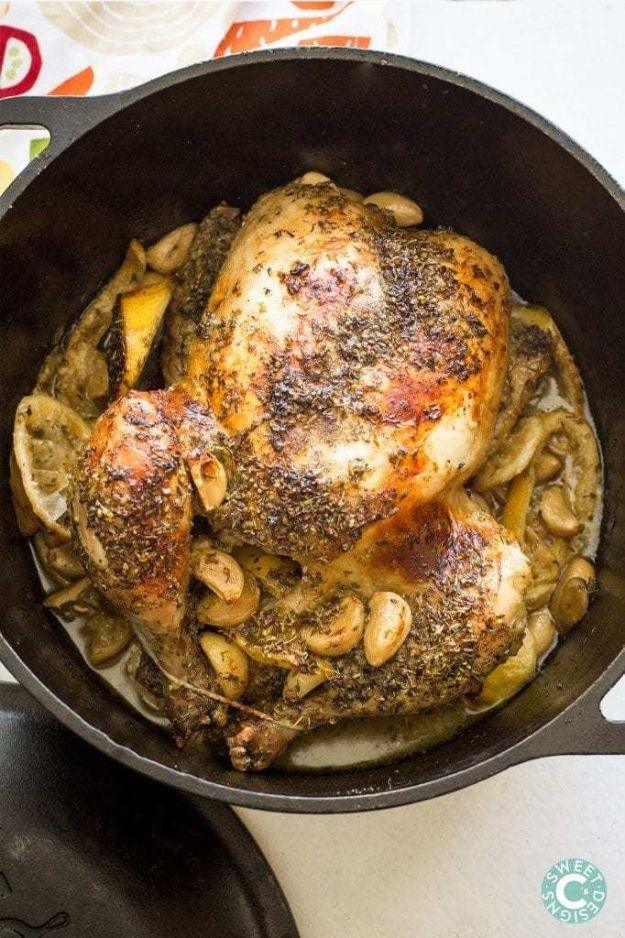 Grecian chicken roasted in a dutch oven with lemon slices, whole peeled garlic cloves and dried oregano